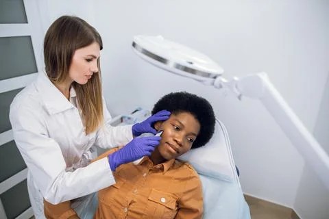 Top angle view of beautiful young African woman getting skin treatment and Stock-Fotos