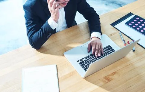 Top angle view of businessman using smart phone and laptop  to working at off Stock Photos