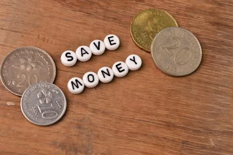 Top angle view of coins and alphabet beads with text SAVE MONEY. Stock Photos