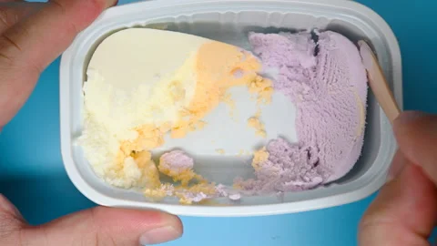 Top angle view eating and finishing the 2nd half of multi-color ice cream Stock Footage 156961151