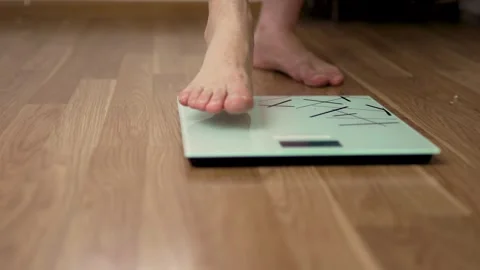 Top Angle View of Foot Stepping on Digital Scale Stockbeeldmateriaal 340220903