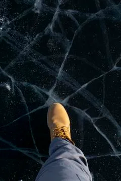 Top angle view of leg standing on broken ice in Lake Baikal, Russia 写真素材