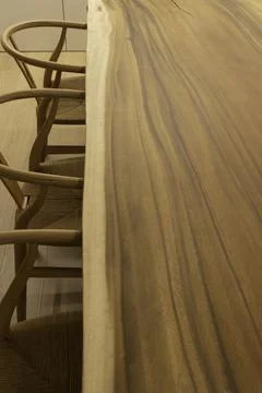 Top angle view of long natural wooden table with wishbone chairs as interior  Stockfoto's