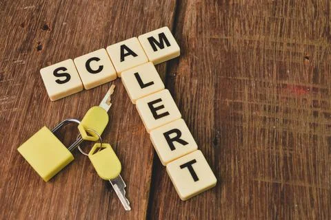 Top angle view of padlock, keys and square letters with text SCAM and ALERT. Stock Photos