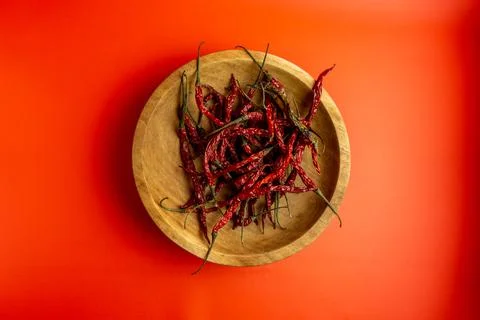 Top angle view of red dried chili in wooden plate on red background Stock Photos
