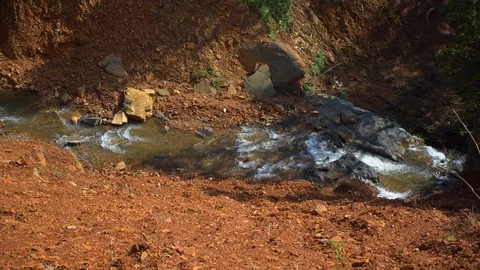 Top angle view of a small stream of water on a muddy road, India 库存影片 119361603