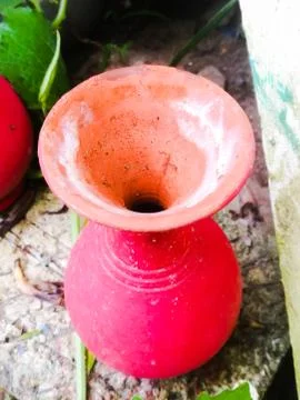 Top angle view of a vibrant red colored earthen pot placed on a brick Stock Photos