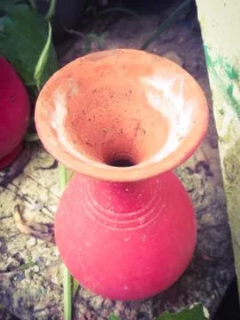Top angle view of a vibrant red colored earthen pot placed in a garden Stock Photos