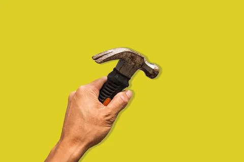 Top angle of a young man holding hammer on yellow background Stock Photos