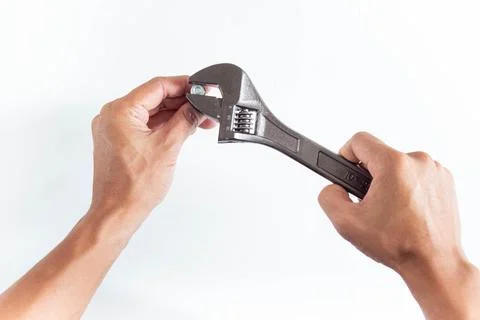 Top angle of young man right handed, using adjustable wrench and screw on whi Stock Photos