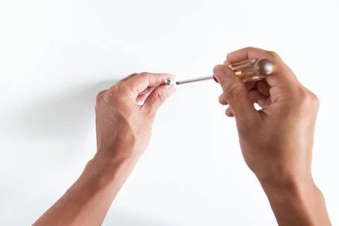 Top angle of young man right handed, holding philip screwdriver and screw on  Stock Photos