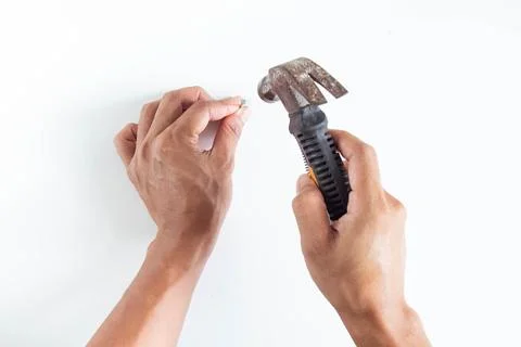 Top angle of young man using hammer and nail isolated on white background Stock Photos