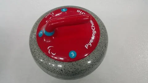 Top angular view of a curling stone on white slippery ice pitch in an arena f Fotos de archivo