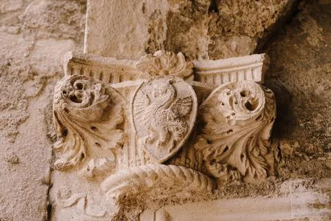 The top of a bas-relief column with a shield pattern depicting a dragon, in the Stock Photos