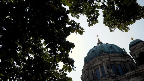Top of Berlin Cathedral building with tree canopy and sun flare Video stock 116250848