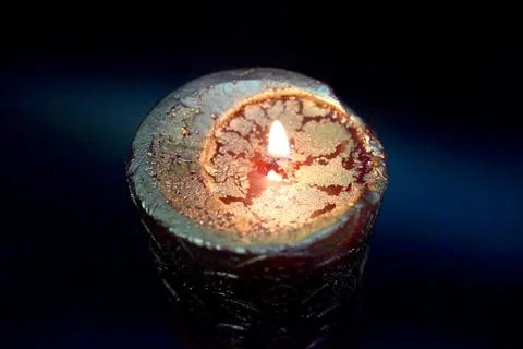 Top of the birning candle with golden layer ob the red wax Stock Photos