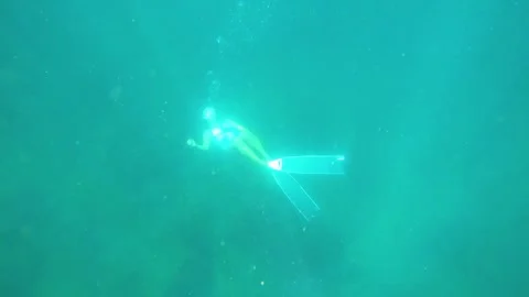 Top to bottom look down view of a young asian free diver wearing  long fins and  Stock Footage 252952863