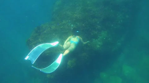 Top to bottom view of a young asian free diver wearing long fins and swim suit f Stock Footage 252953201