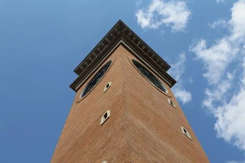 The top of the brick clock tower is visible against the blue sky Foto stock