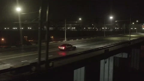 Top cinematic aerial view to the sport car on the bridge at night. BMW M5 2022 Stock Footage 171455531