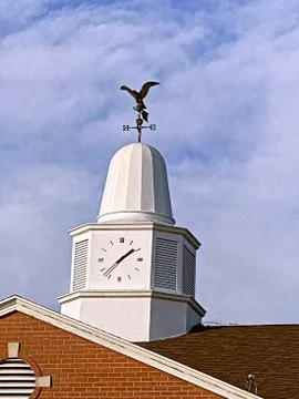 Top of the clock tower and bird-shaped weather vane Stock Photos