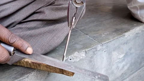 Top close-up shot of an Indian locksmith manually making a duplicate house .. Video stock 313381898