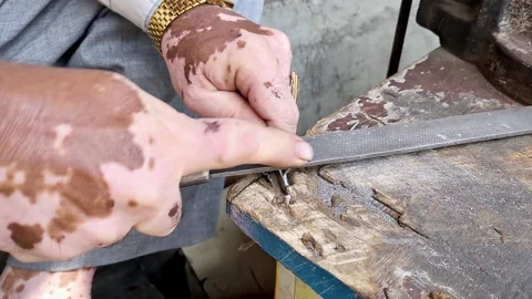 Top close-up shot of an Indian locksmith manually making a duplicate house .. Stock Footage 313381901
