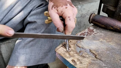 Top close-up shot of an Indian locksmith manually making a duplicate house .. Stock Footage 313381913