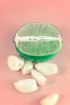 Top close up of a slice of lemon surrounded by garlic cloves over a backgroun Stock Photos