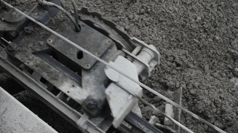 Top close-up view of arm of road paver spreading asphalt concrete over roadway Stock Footage 158049980