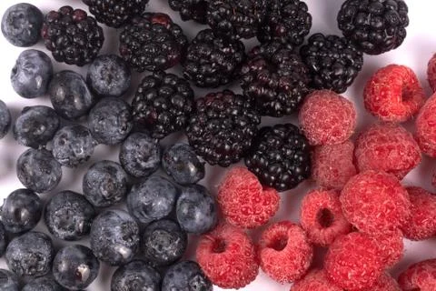Top close-up view on composition of organic red, blue and black summer berrie Stock Photos