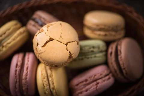Top close view cracked macaroons on wicker basket background Stock Photos