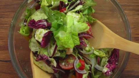 Top close-up view of vegetables and feta cheese cubes mixed with the green sauce Stock Footage 233616435