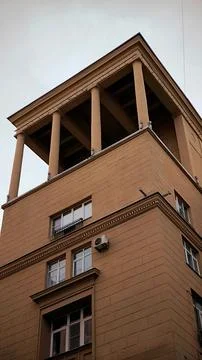 Top corner of a classical yellow building with columns. Fotos Stock