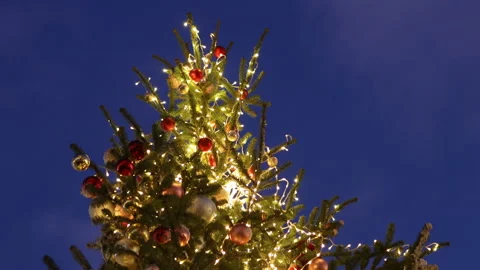 The top of a decorated Christmas tree with shining garlands against the backdrop Stock Footage 165420563