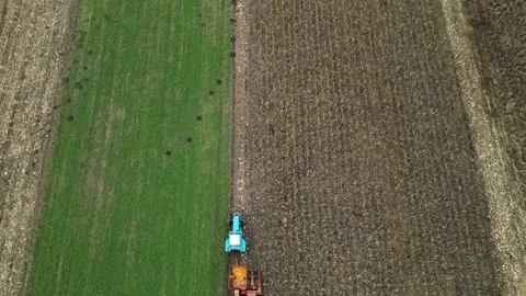 Top down 4K drone view of tractor cultivating field boundary Stock Footage 322933848