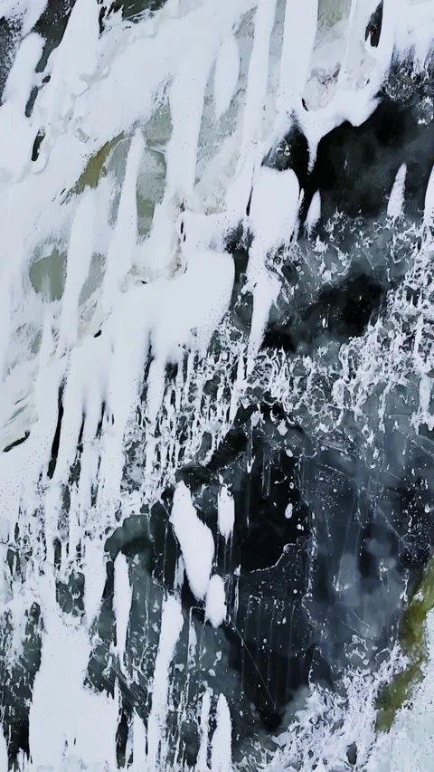 Top-down abstract of dark slush ice with white snow streaks and pale green melt Stock Footage 331657156