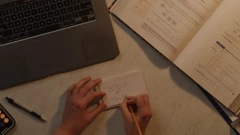 Top Down of Abstract Student Studying for Math Test Using laptop and textbook Stock Footage 217770843
