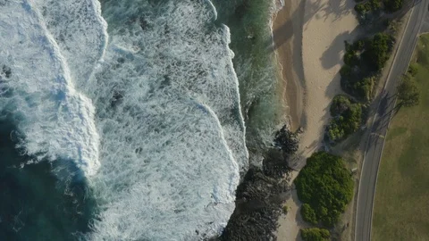 Top down aerial of beach and waves crashing into coast during sunset, Hawaii Stock Footage 126599348