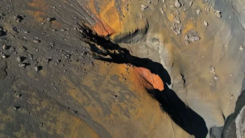 Top-down aerial close-up of a rugged volcanic slope with orange mineral Stockbeeldmateriaal 333225513