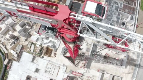 Top-down aerial descent along a tower crane above a residential construction Stock Footage 336286849