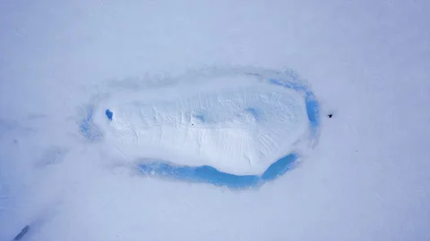Top down aerial drone flight over men running on the lake. Stock Footage 130348476