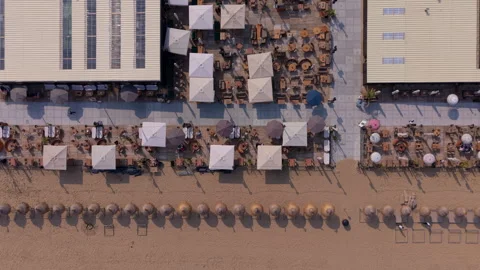 Top-down aerial drone panoramic view of structured coastal beach clubs and .. Stock Footage 337934790