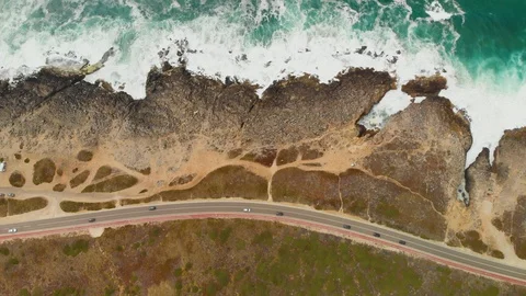 Top down aerial drone shot desolate scenic rocky ocean shore with coastal road Video stock 107962296