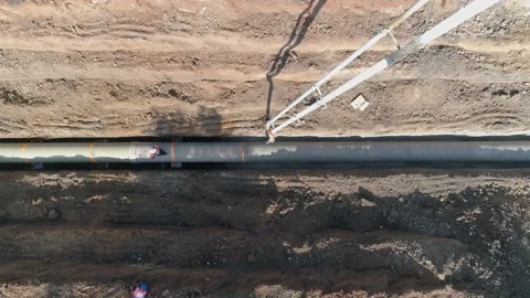 Top down aerial drone shot above big white crane pouring cement on pipeline Stock Footage 131015876