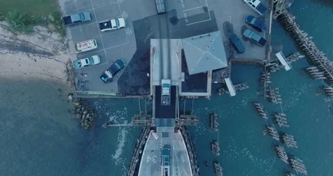 Top Down Aerial Drone shot of Shelter Island New York Ferry unloading at sunrise Stock Footage 255472381