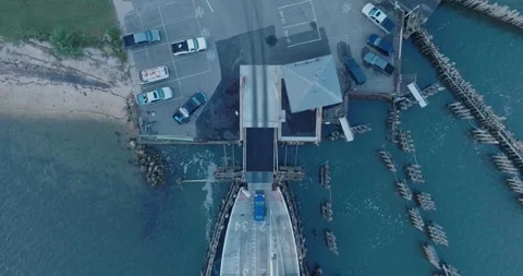 Top Down Aerial Drone shot of Shelter Island New York Ferry unloading at sunrise Stock Footage 255472398