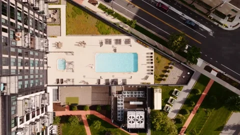 Top down aerial drone shot of an outdoor pool attached to a high rise Stock Footage 281213714