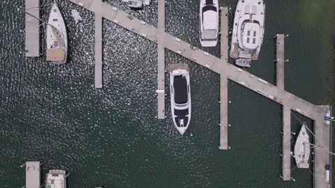Top-down aerial drone shot moving slowly over luxury yacht marina Stock Footage 334726681