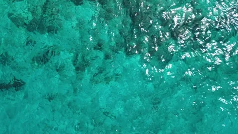 Top Down Aerial Drone Shot of Crystal Clear Turquoise Water Ripples and Sun Stock Footage 344132997